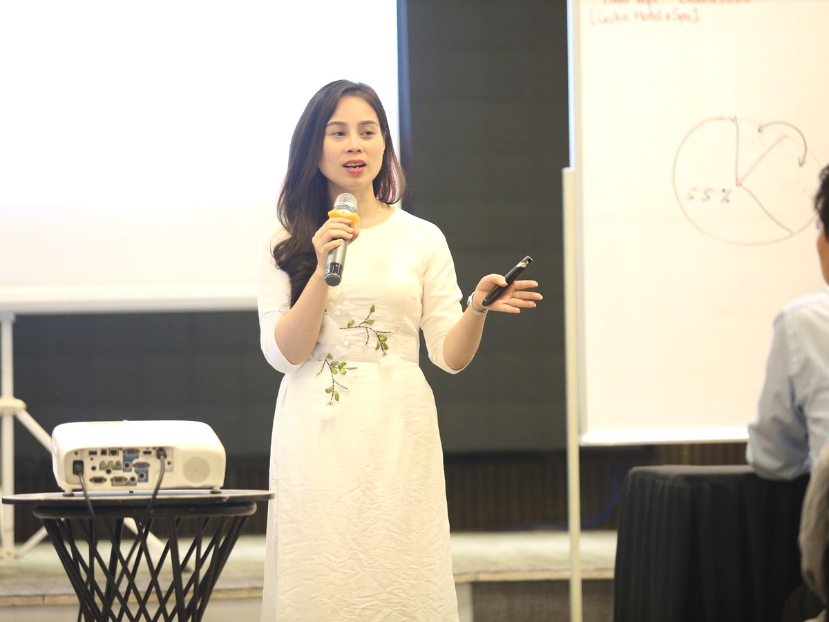 Coach Nguyễn Tú Oanh áo dài trắng giảng trước bảng
